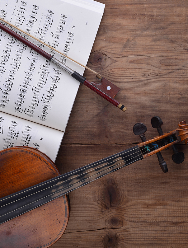 Old violin lying on the sheet of music, music concept