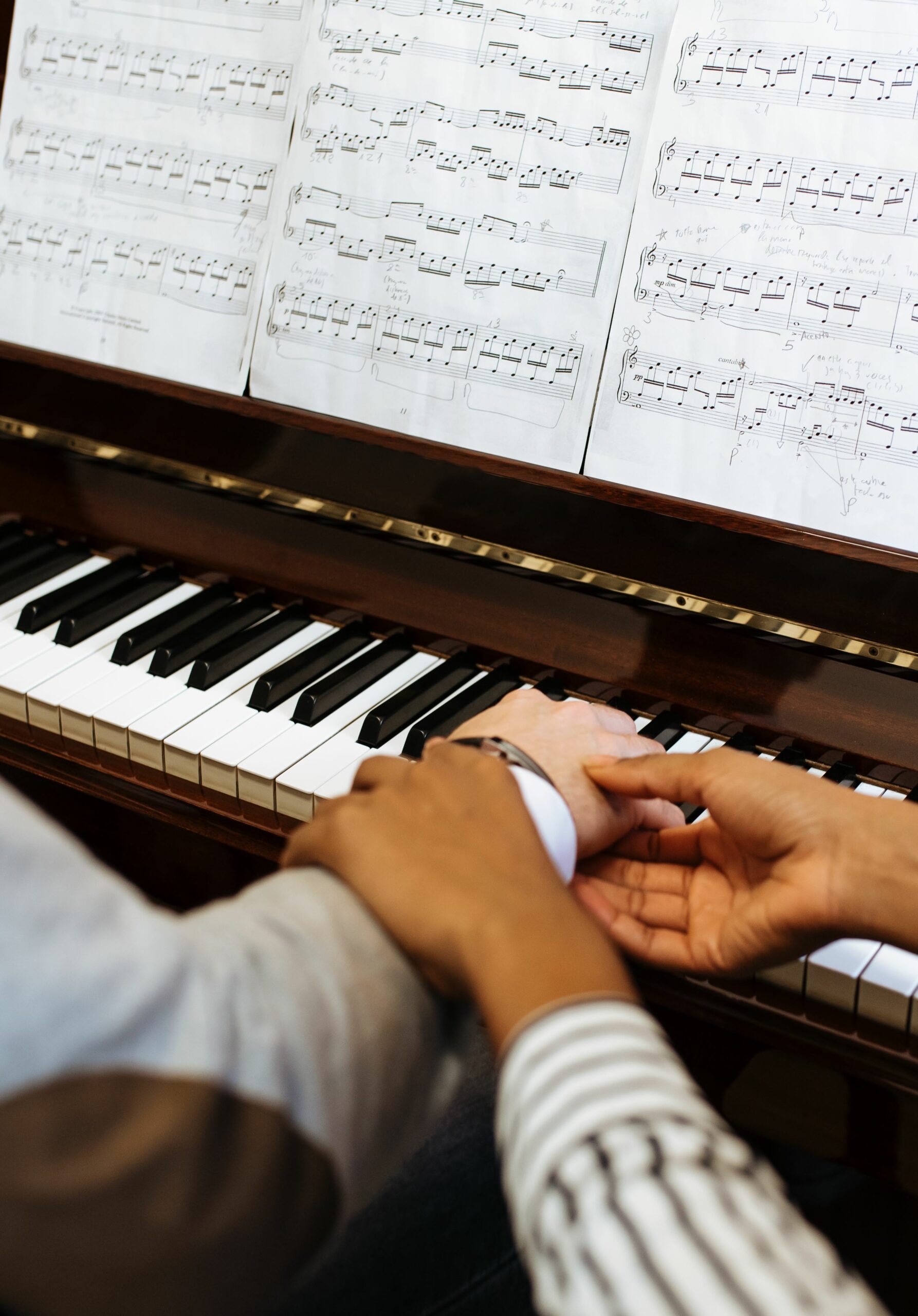 Man playing piano near woman teaching in studio