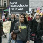 En La Imagen Aparece Un Grupo De Personas Manifestándose Con Pancartas Y Carteles. En Ellos Hay Mensajes En Inglés Contra La Guerra Y La Islamofobia.