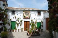 Pretty flowers in pots on house wall in the Barrio la Villa district, Priego de Cordoba, Cordoba Province, Andalusia, Spain, Western Europe.