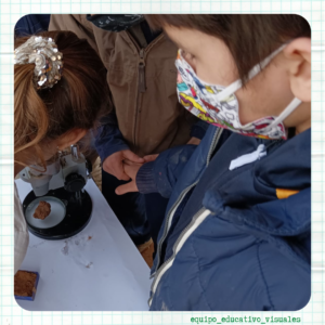 Niños se acercan a mirar por un microscopio